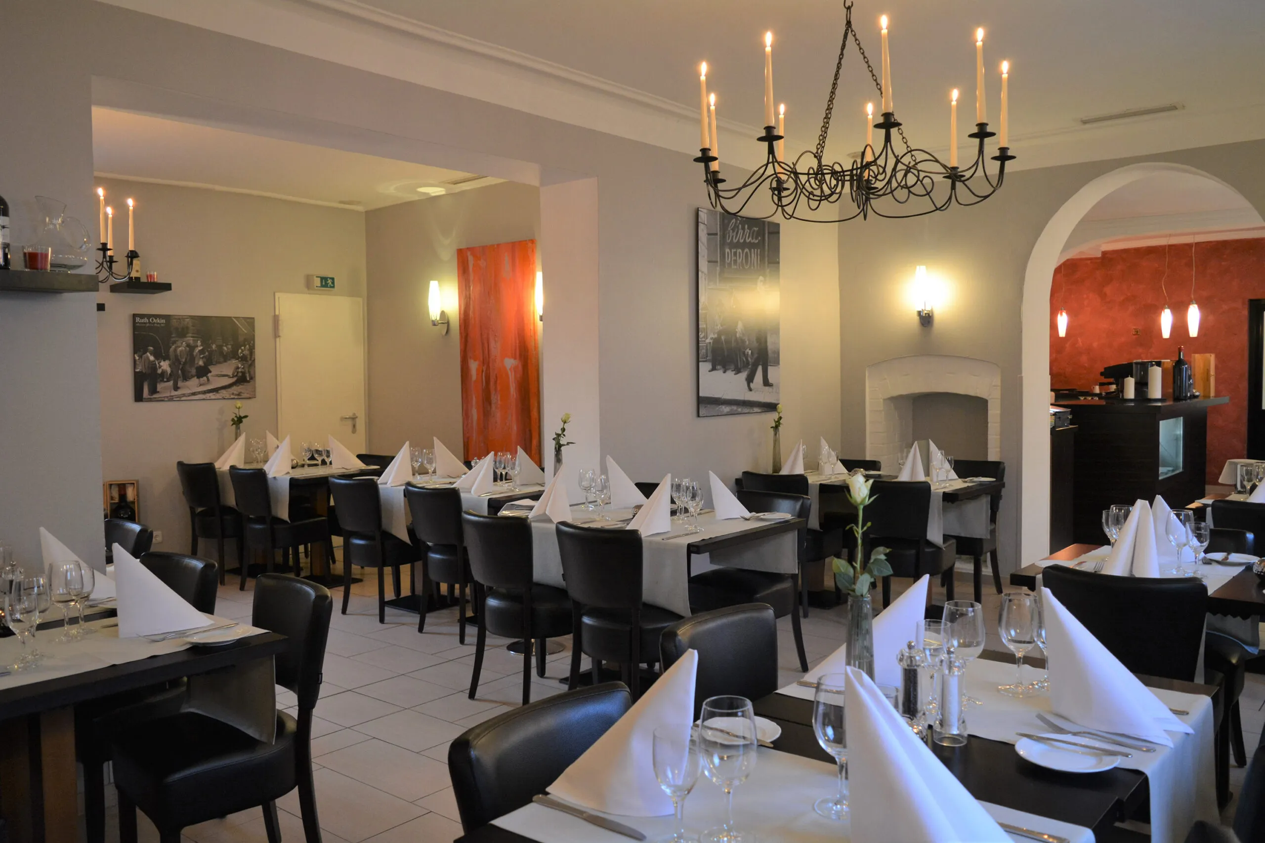 Elegant eingedeckte Tische in einem stilvoll eingerichteten Restaurant mit großem Kronleuchter.