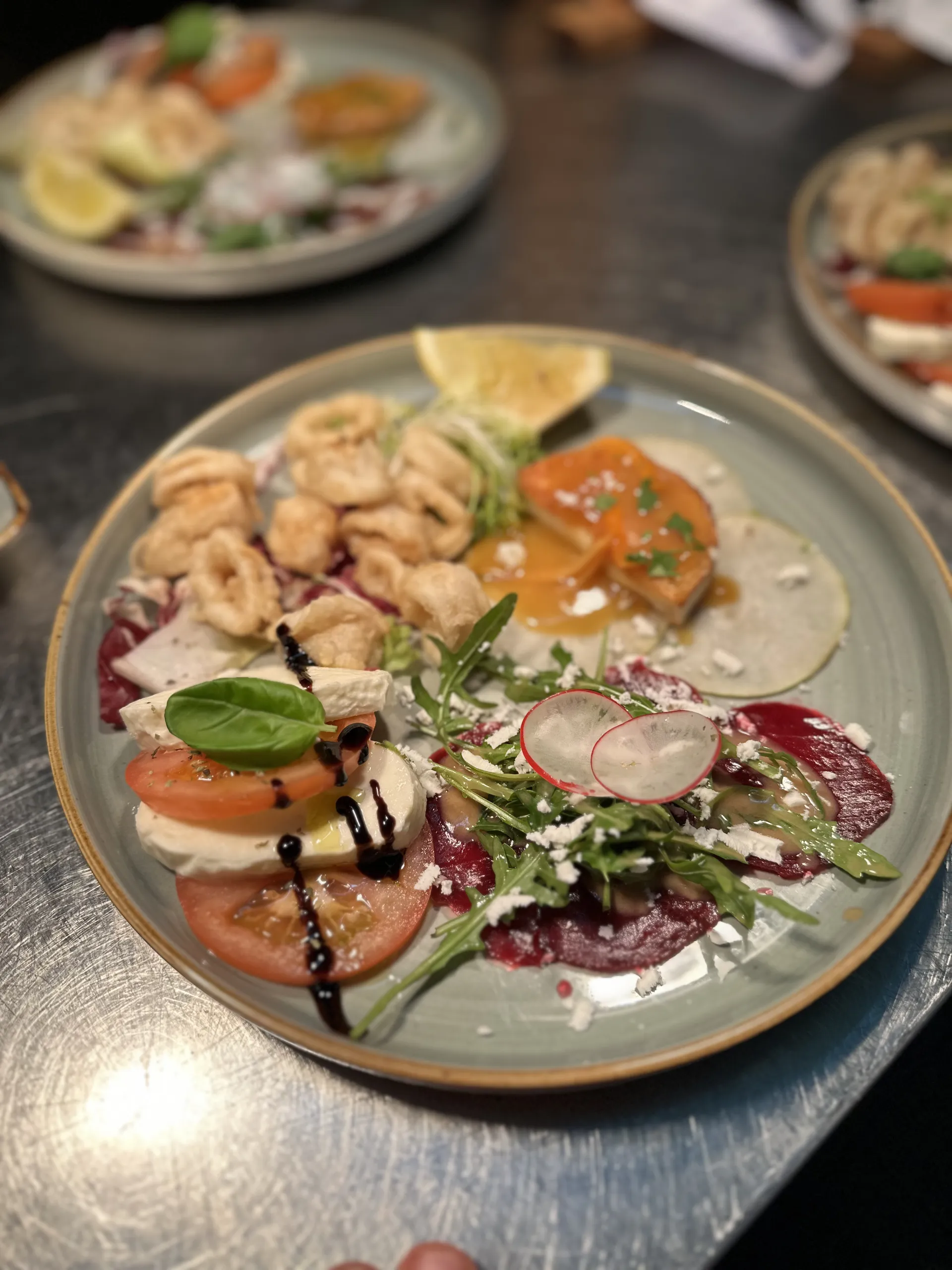 Antipasti-Platte mit Calamari, Caprese und Carpaccio im Restaurant Vittoria.